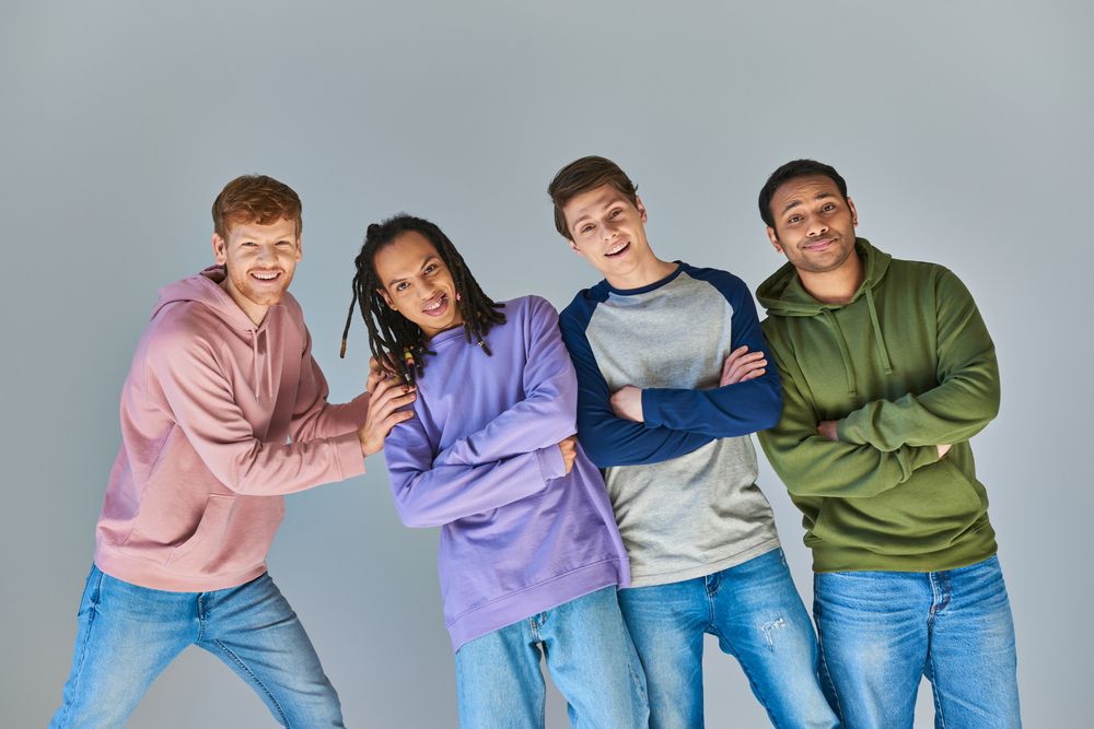 Four Cheerful Men In Casual Outfits Smiling At Cam A36KQX6