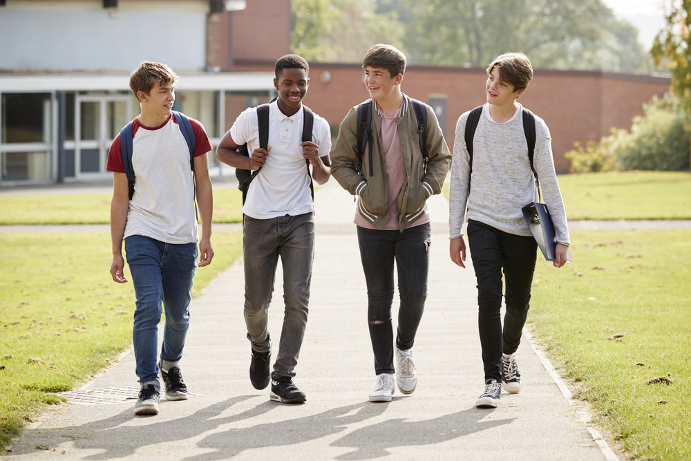 Group Of Male Teenage Students Walking Around Coll PM9WFQ5