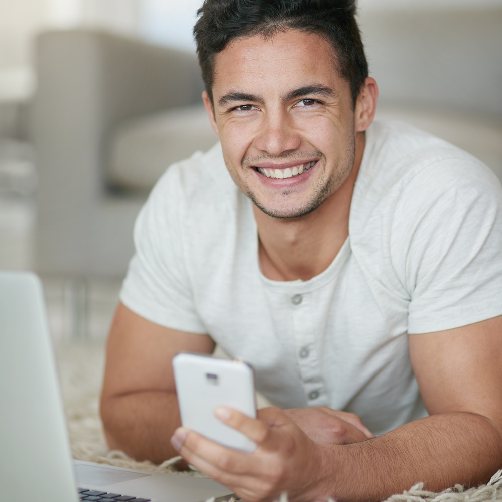Portrait Of A Relaxed Young Man Using A Phone And JHRWE59