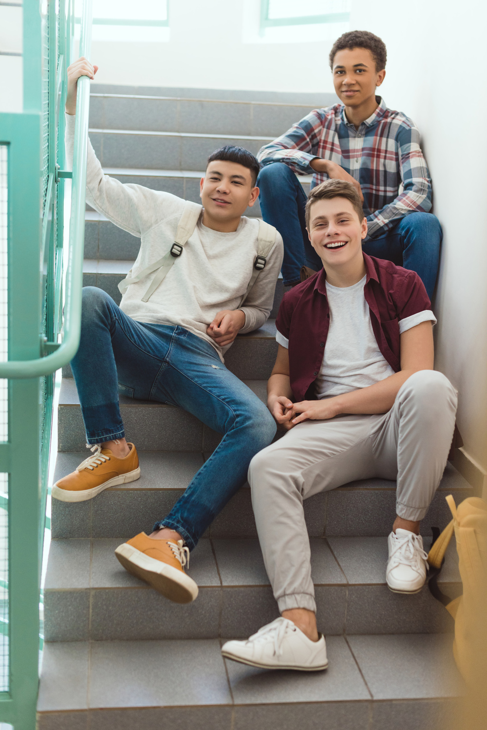Teenage Schoolboys Sitting On Stairs At School And L4MN3UL